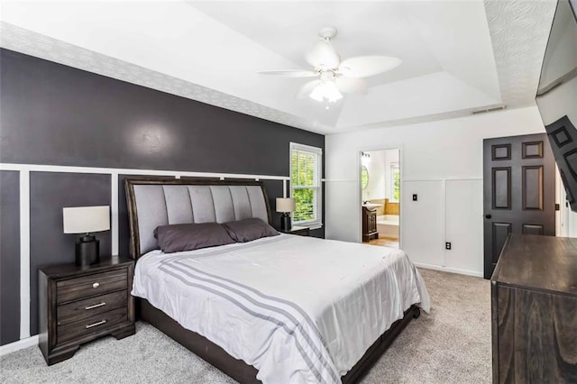 870 Underhill Ct, Sugar Hill, GA 30518 - bedroom with a tray ceiling, light colored carpet, connected bathroom, a ceiling fan, and baseboards