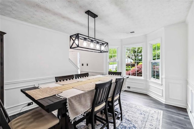 870 Underhill Ct, Sugar Hill, GA 30518 - dining space with dark wood finished floors, a decorative wall, a textured ceiling, a wainscoted wall, and crown molding