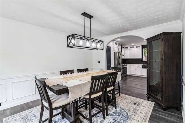 870 Underhill Ct, Sugar Hill, GA 30518 - dining room with arched walkways, crown molding, a wainscoted wall, dark wood finished floors, and a textured ceiling