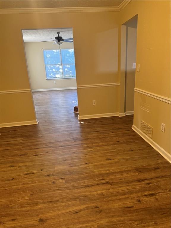 spare room featuring ceiling fan, dark hardwood / wood-style floors, and crown molding