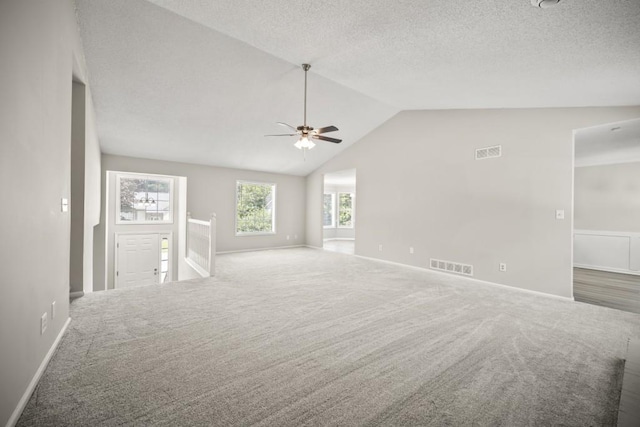 990 Trestle Dr, Austell, GA 30106 - unfurnished living room with carpet floors, vaulted ceiling, ceiling fan, and a textured ceiling