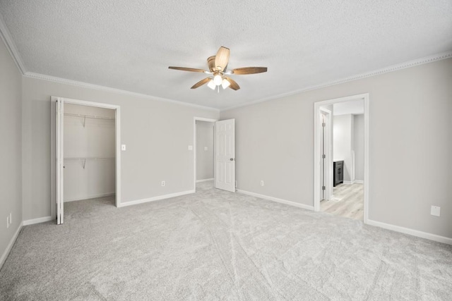 990 Trestle Dr, Austell, GA 30106 - unfurnished bedroom with ornamental molding, a textured ceiling, light carpet, a closet, and ceiling fan
