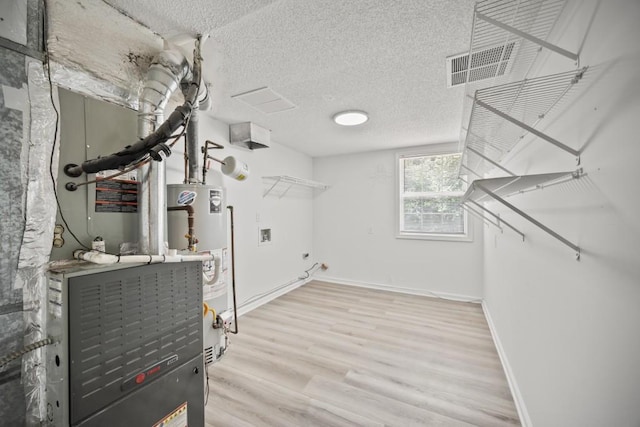 990 Trestle Dr, Austell, GA 30106 - laundry room with gas water heater, hookup for a washing machine, wood finished floors, and a textured ceiling