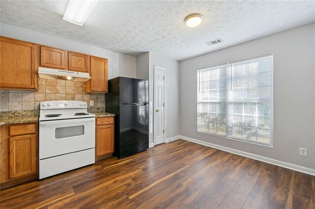 kitchen featuring dark wood-style floors, white range with electric cooktop, visible vents, freestanding refrigerator, and under cabinet range hood