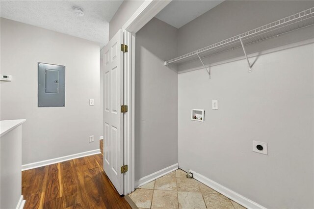 washroom featuring laundry area, electric panel, baseboards, hookup for a washing machine, and hookup for an electric dryer