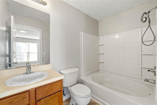 bathroom with bathing tub / shower combination, a textured ceiling, toilet, and vanity