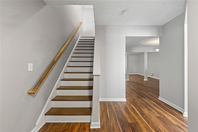 stairway featuring baseboards and wood finished floors