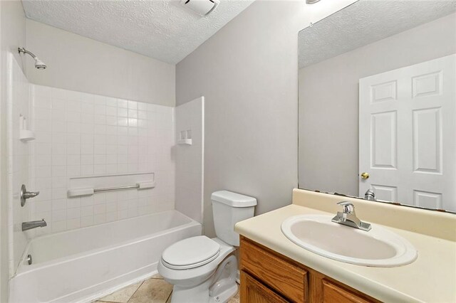 full bath with toilet, tile patterned flooring, a textured ceiling, and vanity