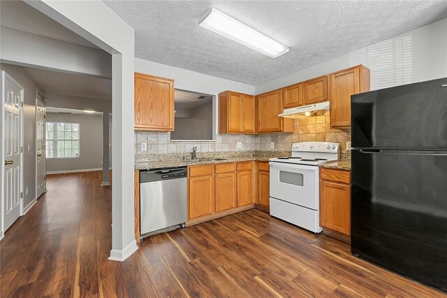 kitchen featuring electric range, freestanding refrigerator, a sink, dishwasher, and under cabinet range hood