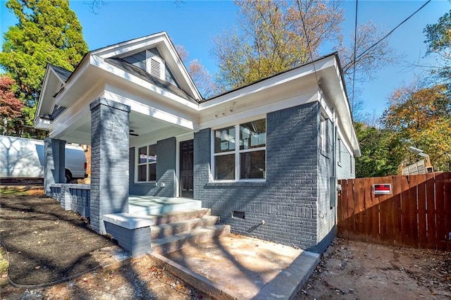 view of front of house featuring brick siding and fence