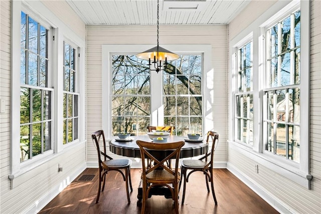 sunroom / solarium featuring a notable chandelier