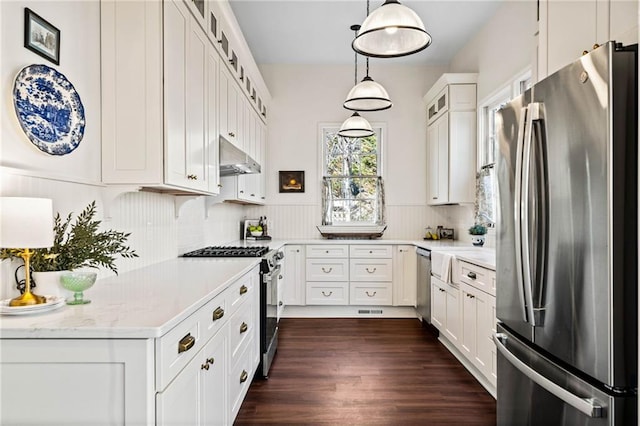 kitchen featuring stainless steel appliances, hanging light fixtures, and white cabinets