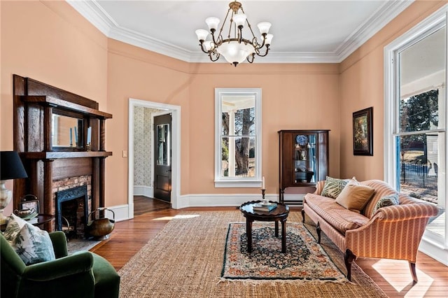 living room featuring hardwood / wood-style flooring, a healthy amount of sunlight, a stone fireplace, and crown molding