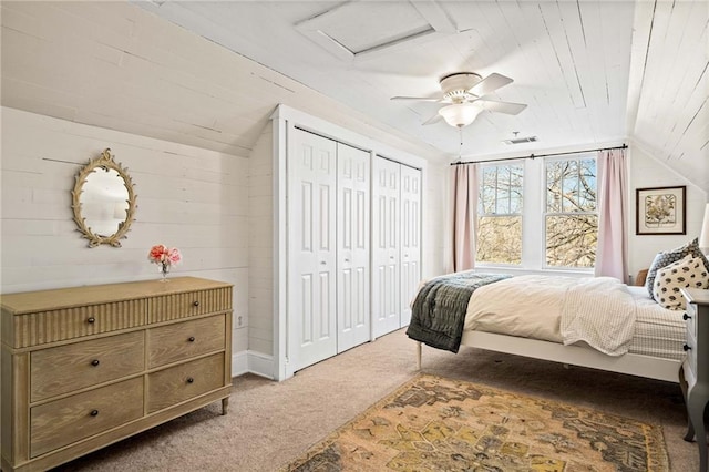 carpeted bedroom with multiple closets, lofted ceiling, wooden ceiling, and ceiling fan