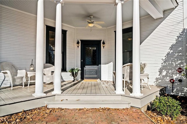 view of exterior entry with a porch and ceiling fan