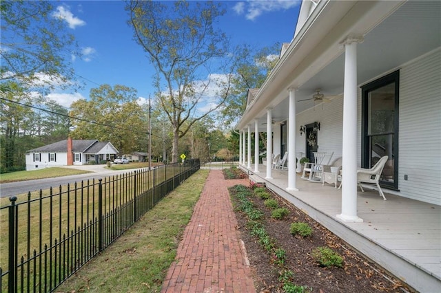 view of yard with ceiling fan and a porch