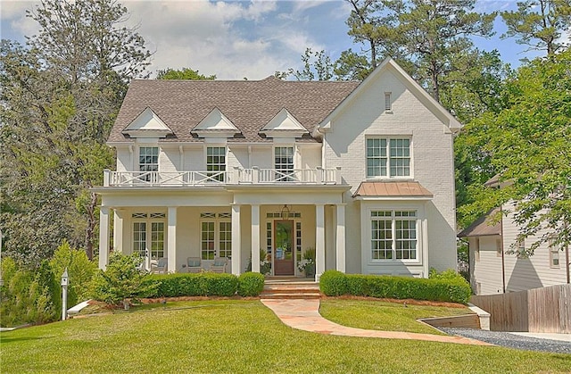 view of front of property featuring fence, covered porch, a front yard, and a balcony