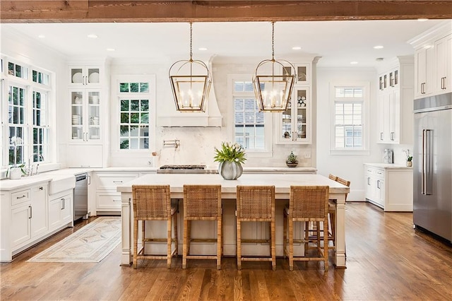 kitchen with a kitchen island, stainless steel appliances, an inviting chandelier, and white cabinetry