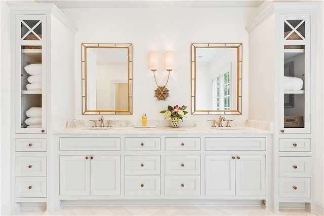 full bath featuring double vanity, a sink, and crown molding