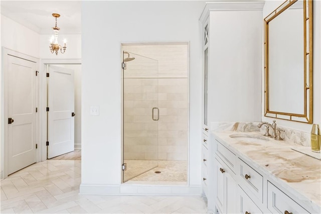 full bath with vanity, baseboards, an inviting chandelier, and a shower stall