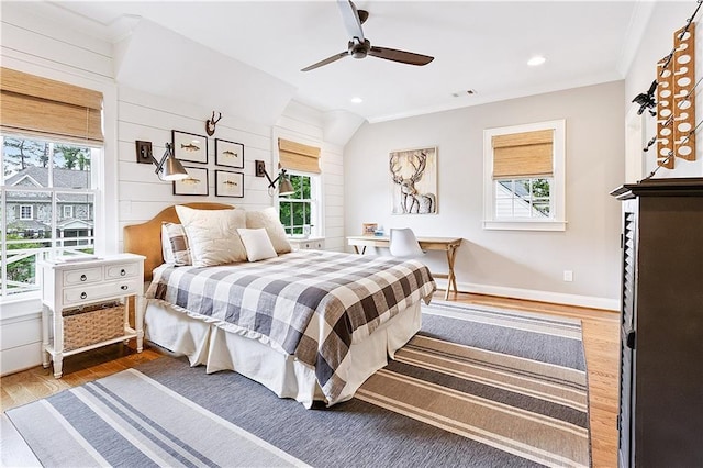 bedroom with crown molding, wood finished floors, and multiple windows