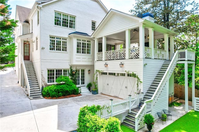 view of front facade featuring fence, brick siding, concrete driveway, an attached garage, and stairway