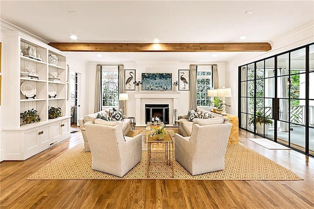 living area featuring a fireplace, recessed lighting, beamed ceiling, and light wood finished floors