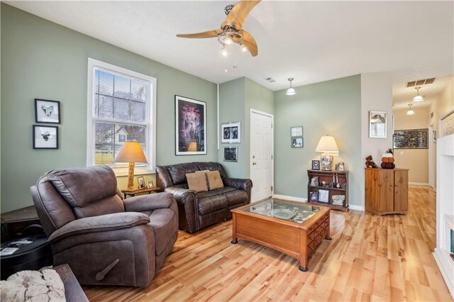 living room with ceiling fan and light hardwood / wood-style flooring