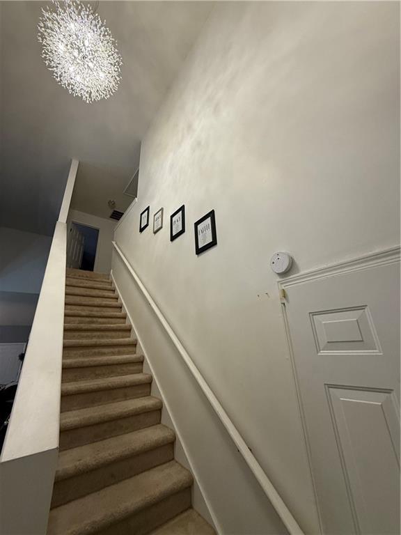 staircase featuring an inviting chandelier