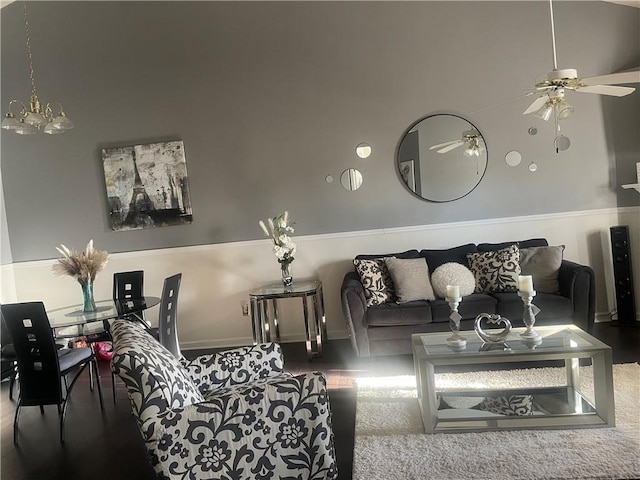 living area featuring ceiling fan with notable chandelier
