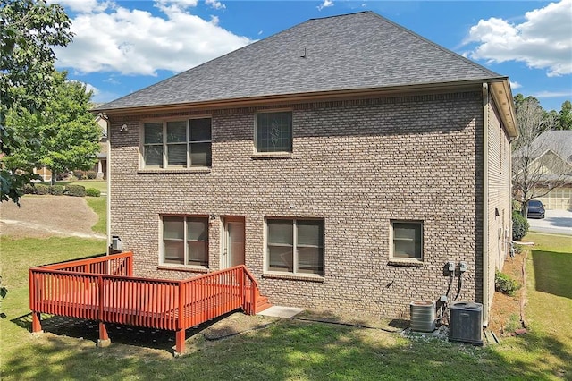 rear view of property featuring cooling unit, a deck, and a yard