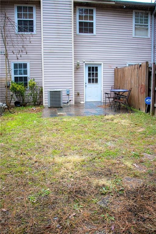 back of house with a patio and a lawn