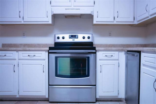 kitchen with white cabinetry, stainless steel electric range oven, and light tile patterned floors