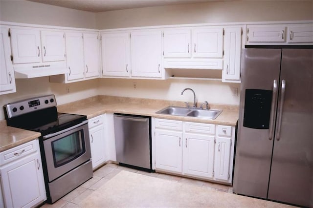 kitchen with sink, light tile patterned floors, white cabinets, and appliances with stainless steel finishes