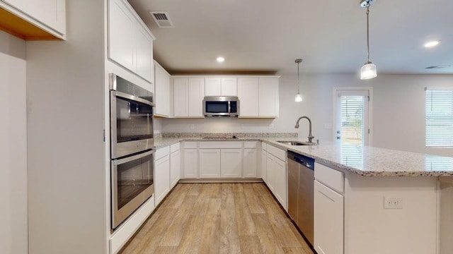 142 Post Oak Dr, Jackson, GA 30233 - kitchen featuring a sink, appliances with stainless steel finishes, a peninsula, light wood-style flooring, and recessed lighting