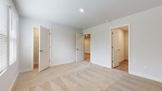 142 Post Oak Dr, Jackson, GA 30233 - unfurnished bedroom with light carpet, multiple windows, baseboards, a walk in closet, and recessed lighting