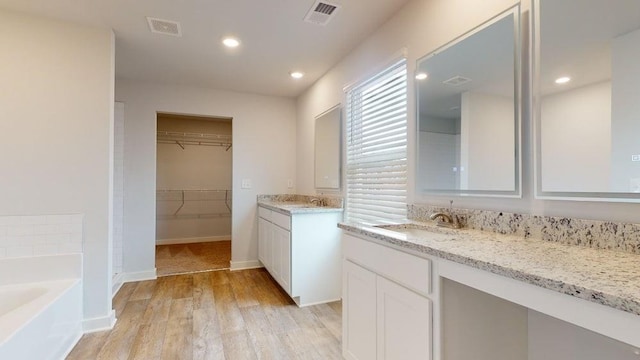 142 Post Oak Dr, Jackson, GA 30233 - full bathroom with a garden tub, wood finished floors, vanity, recessed lighting, and a walk in closet