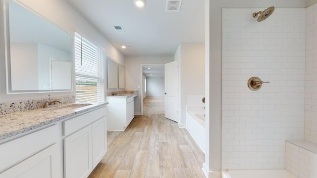142 Post Oak Dr, Jackson, GA 30233 - full bath featuring tiled shower, two vanities, a garden tub, wood finished floors, and recessed lighting