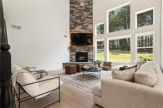 7985 Welch Ml, Ball Ground, GA 30107 - living room with a high ceiling, wood finished floors, plenty of natural light, a fireplace, and baseboards
