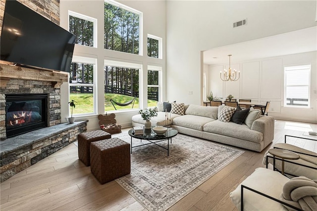 7985 Welch Ml, Ball Ground, GA 30107 - living room featuring a towering ceiling, wood-type flooring, a fireplace, and a chandelier