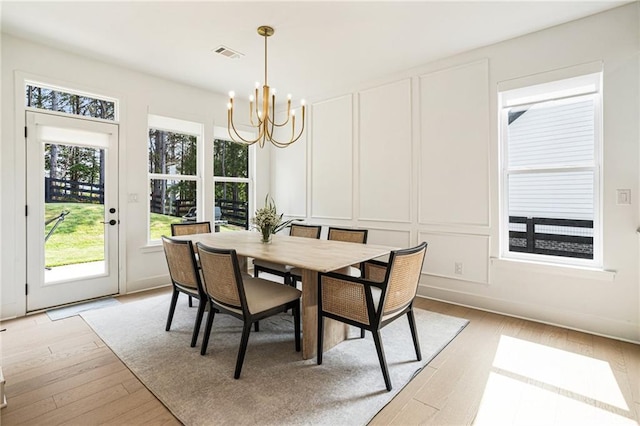 7985 Welch Ml, Ball Ground, GA 30107 - dining area featuring a chandelier, a decorative wall, and light wood-style floors