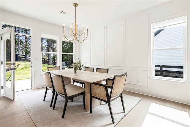 7985 Welch Ml, Ball Ground, GA 30107 - dining space with a decorative wall, a chandelier, and light wood finished floors