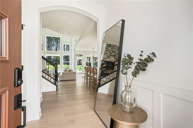 7985 Welch Ml, Ball Ground, GA 30107 - entryway with light wood-type flooring, arched walkways, a decorative wall, stairway, and a wainscoted wall