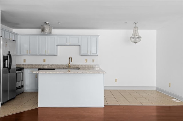 1102 Madison Ln SE Unit 1102, Smyrna, GA 30080 - kitchen featuring stainless steel appliances, light tile patterned floors, light stone countertops, and pendant lighting