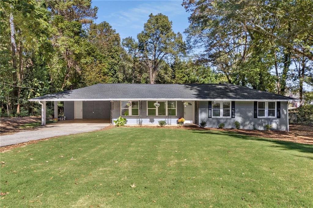 ranch-style home featuring a front lawn and a carport