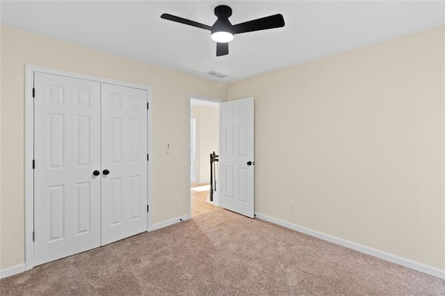 unfurnished bedroom with carpet floors, baseboards, visible vents, and a closet