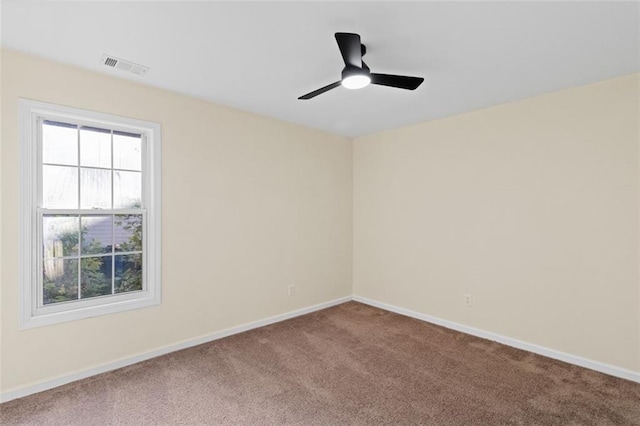 spare room featuring a ceiling fan, carpet flooring, visible vents, and baseboards