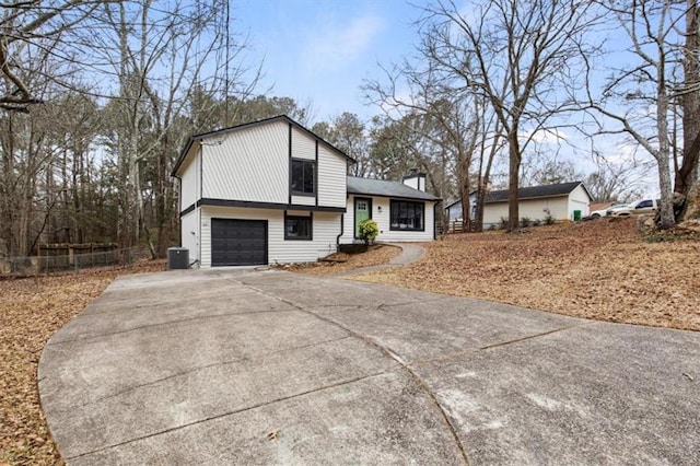 split level home with cooling unit and a garage