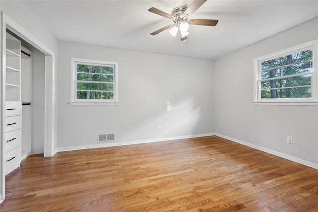 unfurnished bedroom featuring light wood-type flooring, ceiling fan, and a closet