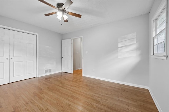 unfurnished bedroom featuring light hardwood / wood-style flooring, a closet, and ceiling fan